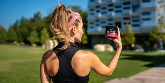 Woman holding VitaUp Beetroot Cardio+ Gummies before workout outdoors